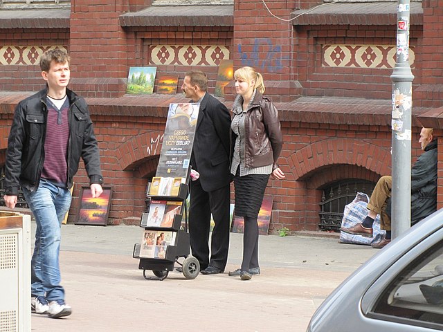 JW members evangelizing on a sidewalk with religious materials.